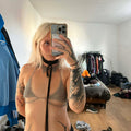 Person taking a mirror selfie in a room with clothes and shoes on the floor.
